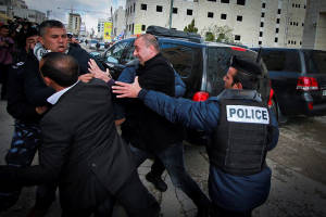 Palestinians held back as they try to assault Canadian FM Baird. (Photo: Flash90) 
