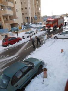 Fire department in Efrat hoses down the snow in an attempt to clear the road.  Photo: Daniel Sass