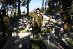 Israeli soldiers solute graves of fallen Israeli soldiers