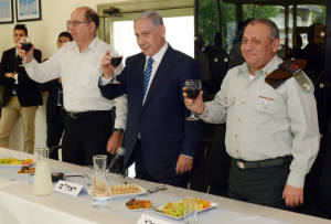 Prime Minister Benjamin Netanyahu (C), Defense Minister Moshe Boogie Yaalon (L), and IDF Chief of Staff, Gabi Eizenkott (R), toast during a meeting of the Israeli Defence Force (IDF) General Staff