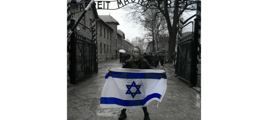 Girl Stands Outside Auschwitz Holding Israel Flag