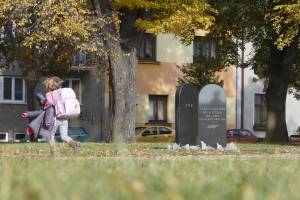 A young girl walks past a memorial to the former Jewish cemetery in Prostejov. 