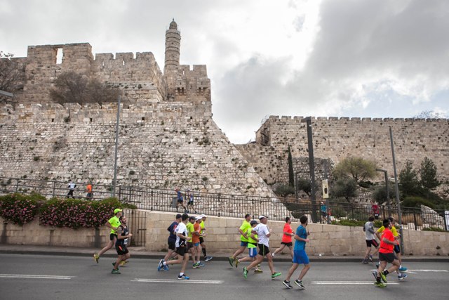 Runners pass the Tower of David as they participate in the annual marathon in Jerusalem. (AP/Dan Balilty)