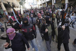 In this Feb. 10, 2012 photo, Syrian rebels march in a show of strength during a demonstration in Idlib, Syria. (AP Photo, File)
